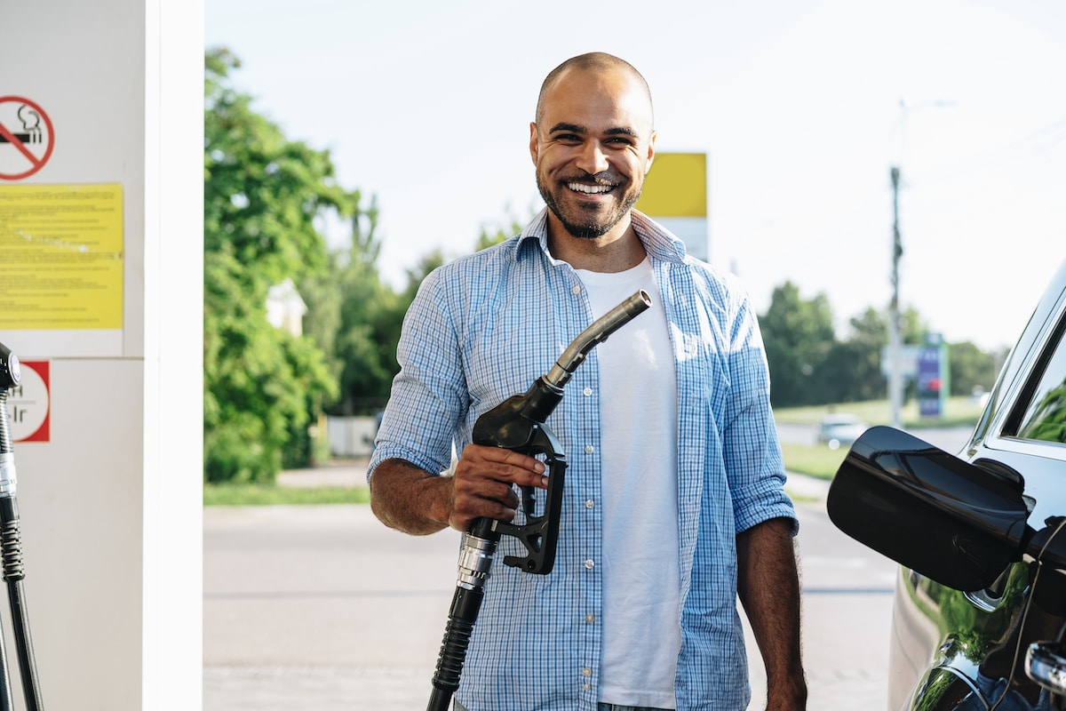 Man filling gasoline fuel in car at gas station, close up