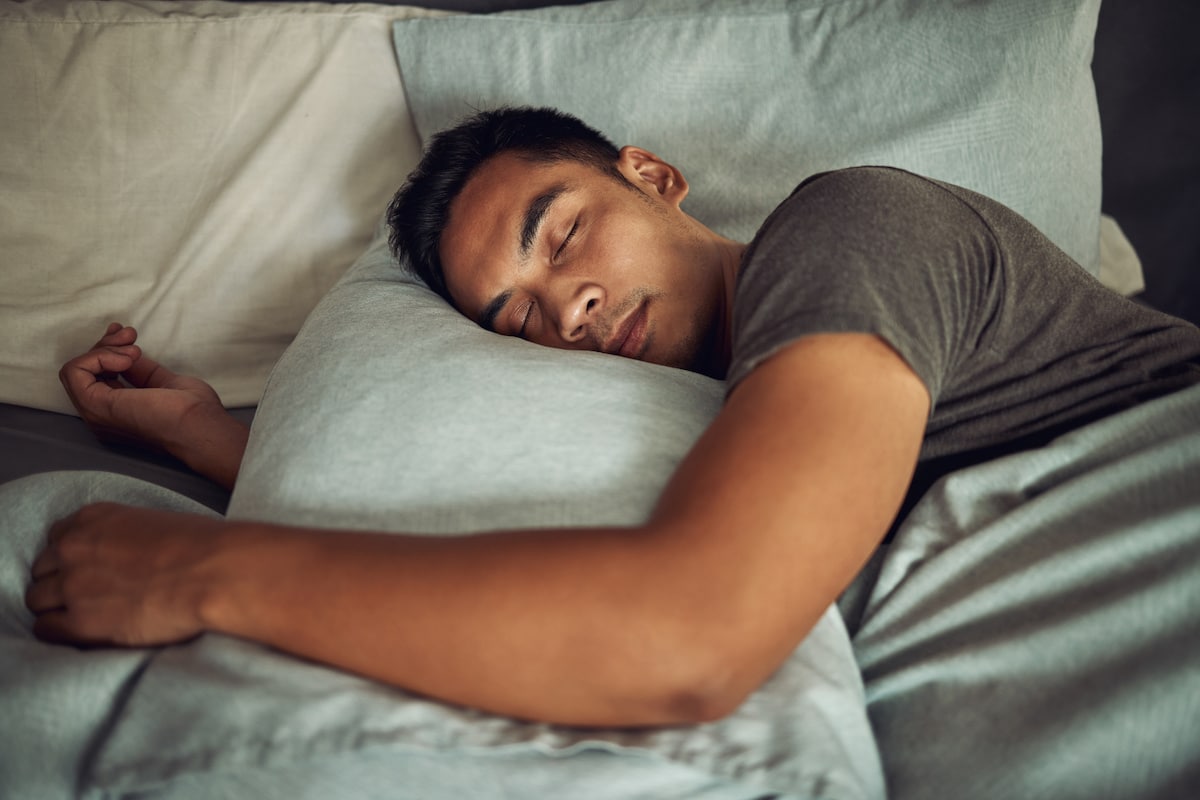 Young man sleeping peacefully in bed at home.